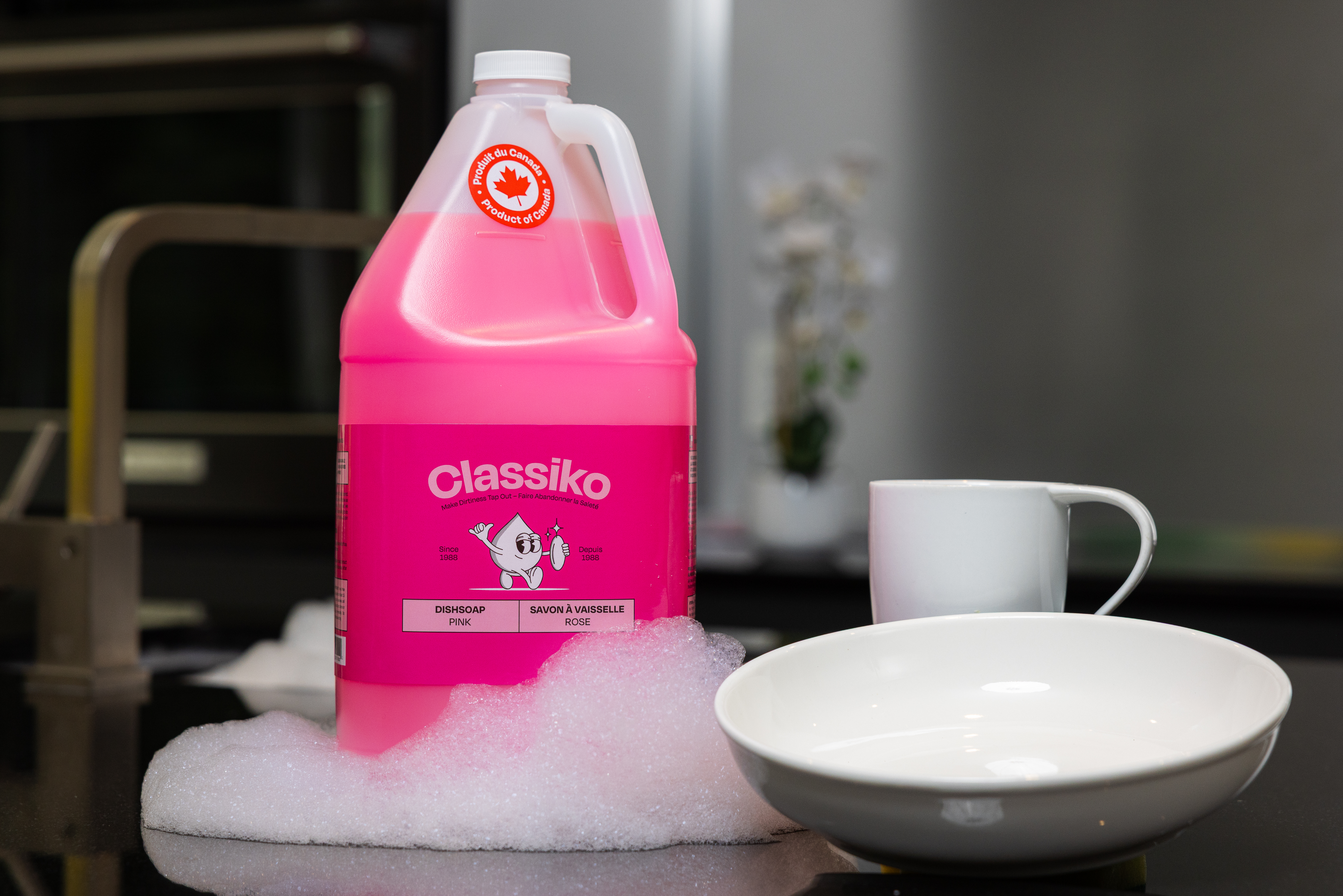 Pink dish soap bottle with bubbles.